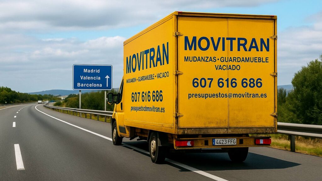 Camión amarillo de Movitran circulando por la autopista en dirección a Madrid, Barcelona y Valencia, servicio de mudanzas nacionales.